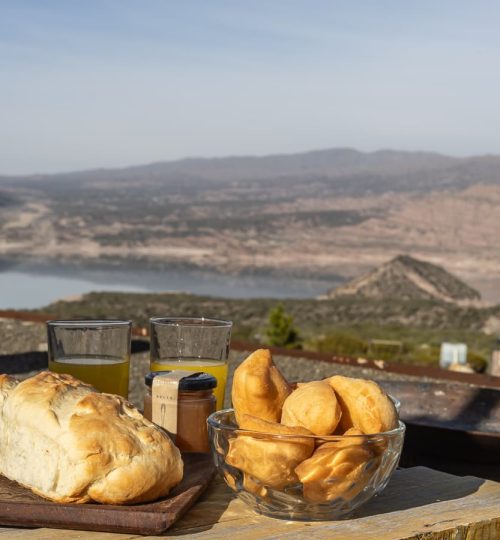 Desayuno con vista al Dique Potrerillos desde el Deck exterior de una Cabaña de 'La Calma Ecolodge' en Mendoza, Argentina.