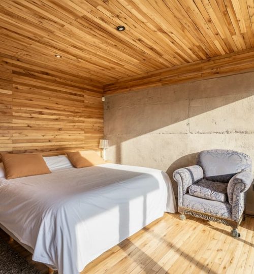 Interior diurno del dormitorio de una Cabaña de 'La Calma Ecolodge' en Potrerillos, Mendoza, Argentina.