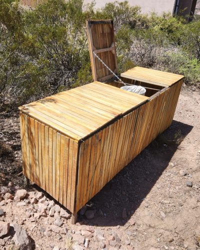 Contenedor de reciclaje en zona común del eco lodge con diseño en madera.
